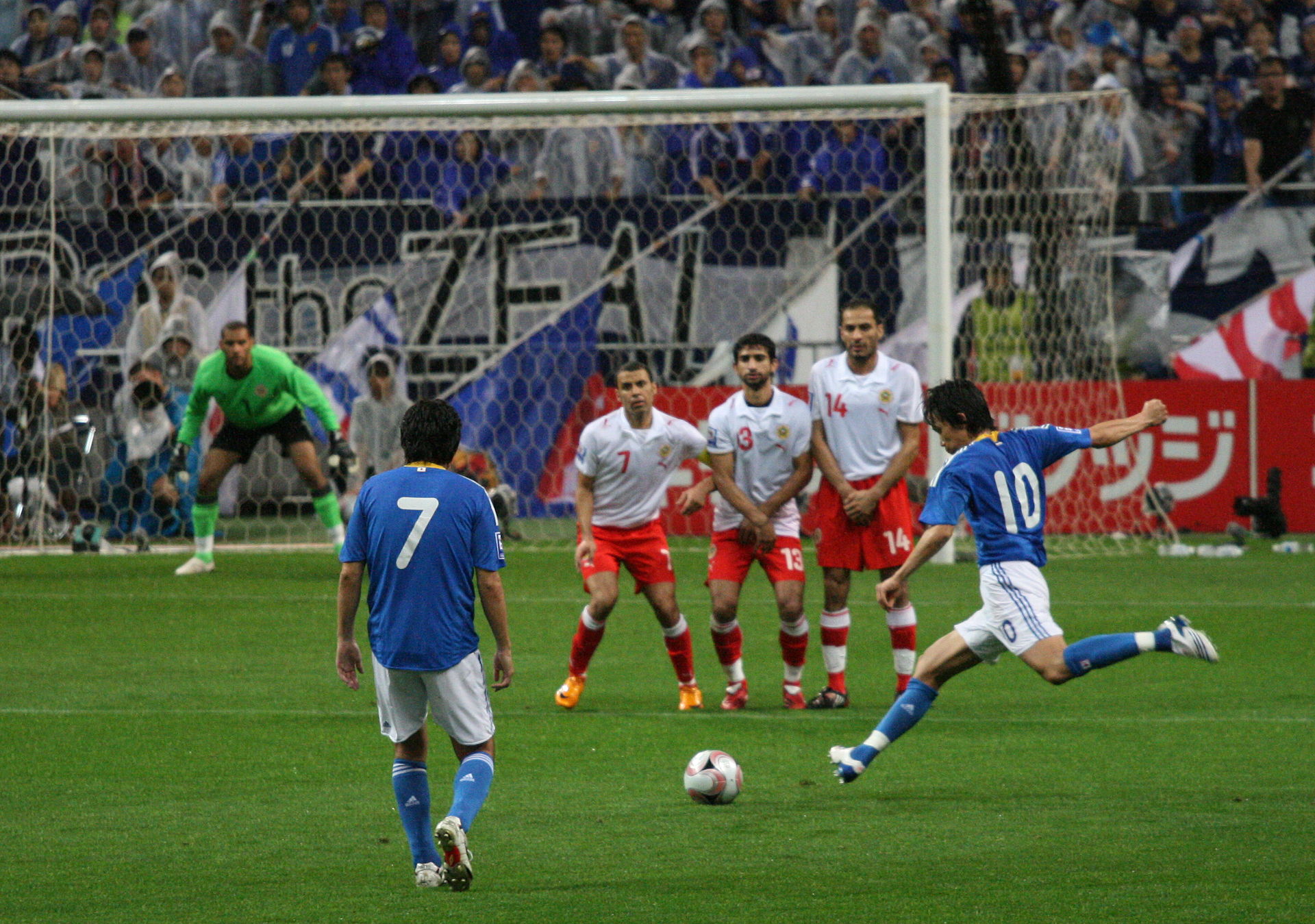 A player takes a free kick, while the opposition form a wall